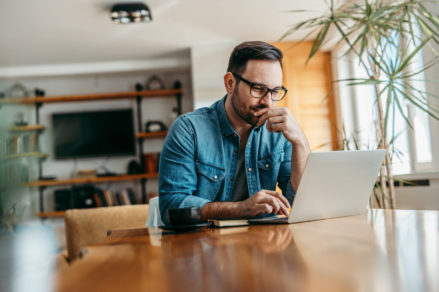 man with glasses at his laptop